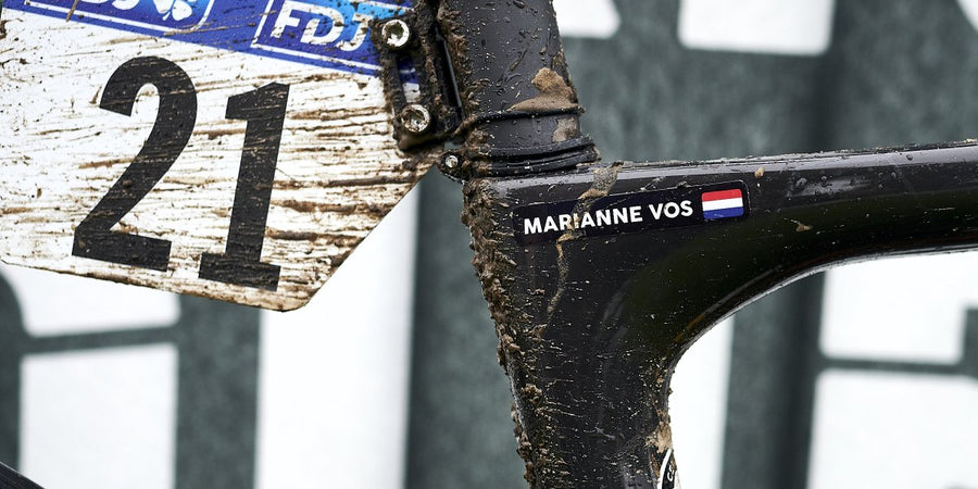 Naamsticker van Marianne Vos op haar fiets onder de modder na Parijs-Roubaix