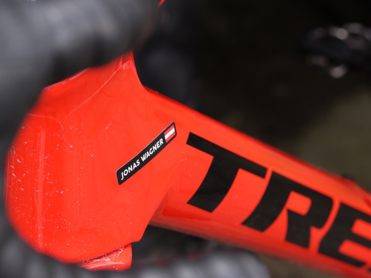 Zwarte naamsticker met Oostenrijkse vlag op een rood fietsframe
